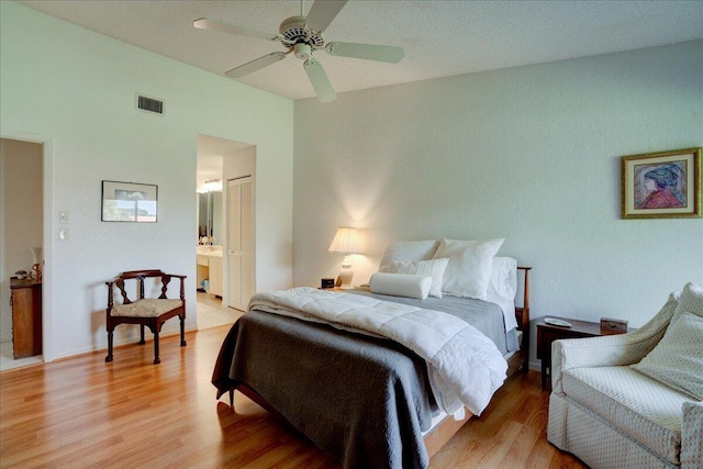 bedroom featuring ensuite bath, ceiling fan, a closet, and light hardwood / wood-style floors