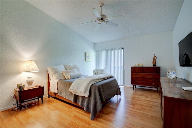 bedroom featuring ceiling fan, light wood-type flooring, and lofted ceiling