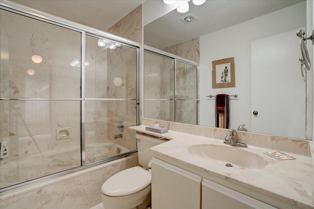 full bathroom with vanity, bath / shower combo with glass door, and toilet