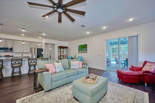 living room featuring ceiling fan and dark wood-type flooring