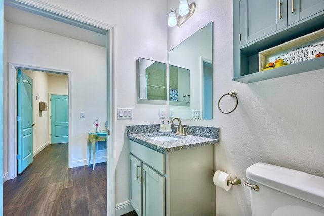 bathroom with hardwood / wood-style floors, vanity, and toilet