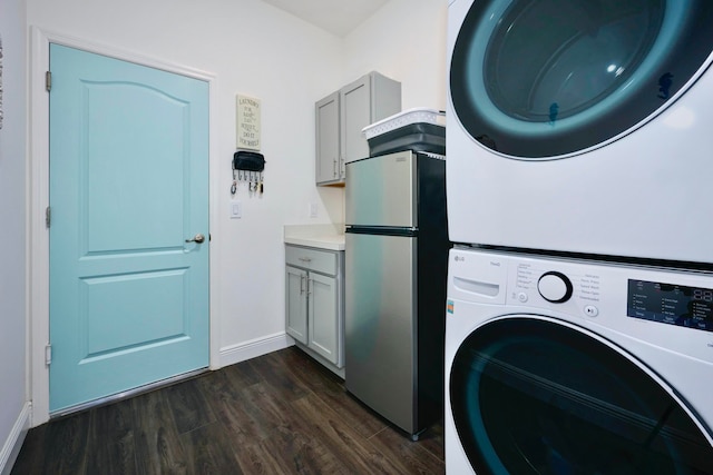 clothes washing area featuring cabinets, dark hardwood / wood-style floors, and stacked washer / dryer