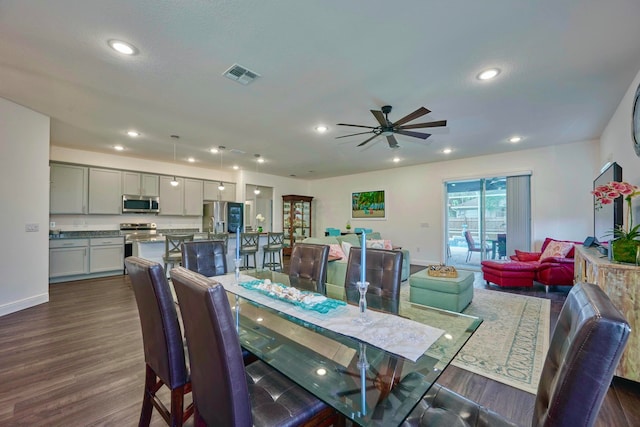 dining space with ceiling fan and dark wood-type flooring