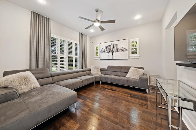 living room featuring dark wood-type flooring, ceiling fan, and a healthy amount of sunlight