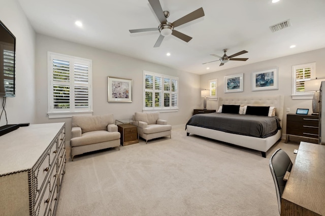 carpeted bedroom with ceiling fan and multiple windows