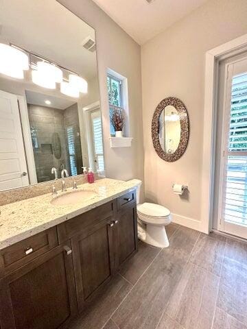 bathroom featuring hardwood / wood-style flooring, vanity, toilet, and a shower with door