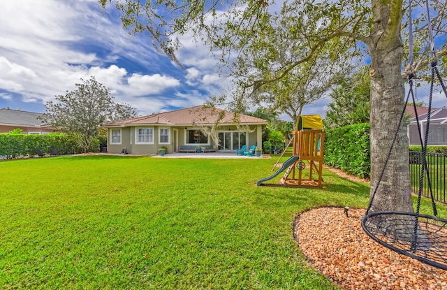 2233 SW Golden Bear Way, Palm City, FL 34990 - back of property with a playground, a patio, and stucco siding