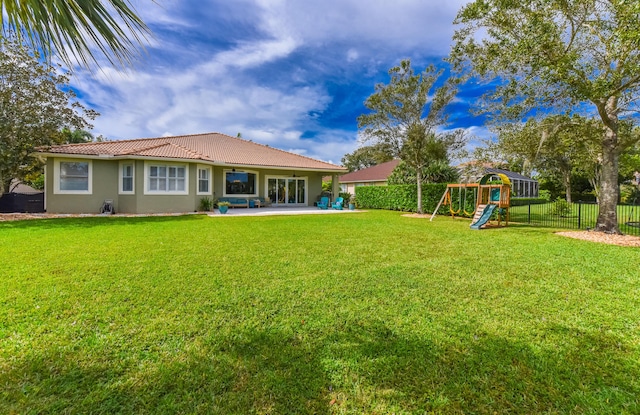 2233 SW Golden Bear Way, Palm City, FL 34990 - rear view of property featuring a playground, a tiled roof, stucco siding, and a patio