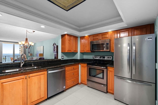 kitchen featuring a chandelier, appliances with stainless steel finishes, dark stone counters, and sink