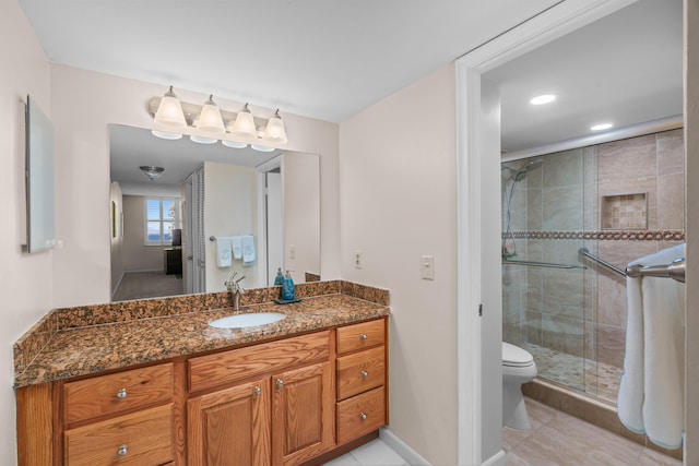 bathroom featuring tile patterned flooring, vanity, an enclosed shower, and toilet