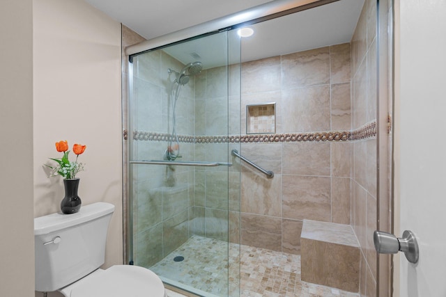 bathroom featuring walk in shower and toilet