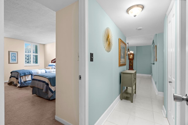 corridor featuring a textured ceiling and light colored carpet