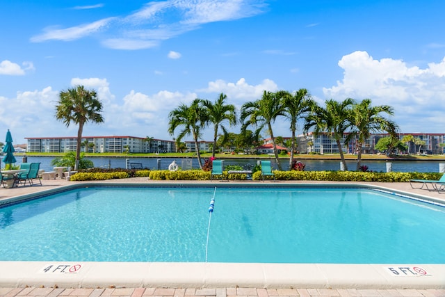 view of swimming pool featuring a patio area and a water view