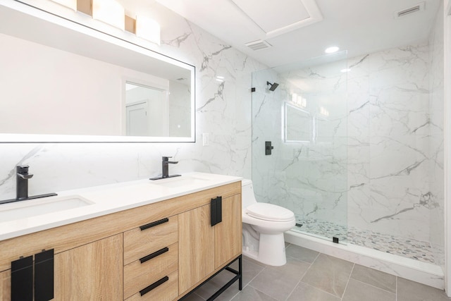 bathroom with tiled shower, vanity, tile walls, and toilet