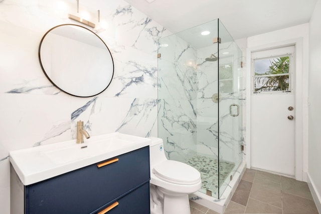 bathroom featuring vanity, a shower with door, tile patterned flooring, toilet, and tile walls