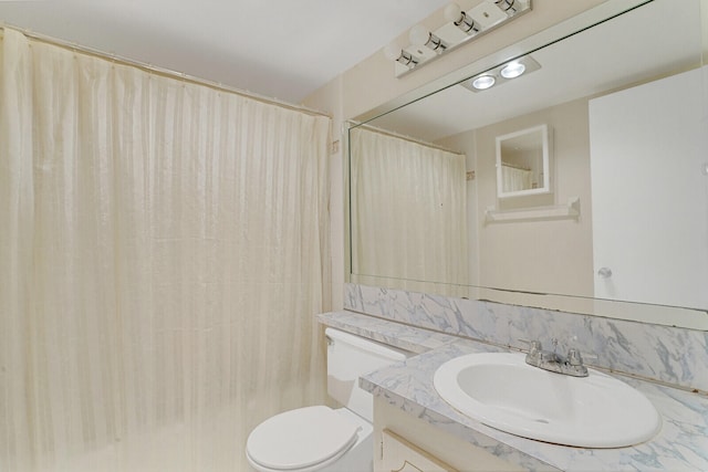 bathroom featuring a shower with shower curtain, vanity, and toilet