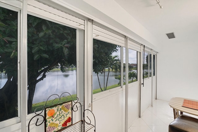 doorway to outside featuring light tile patterned floors and a water view