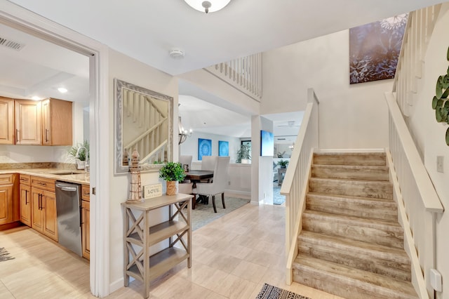 stairs featuring tile patterned floors, an inviting chandelier, and sink