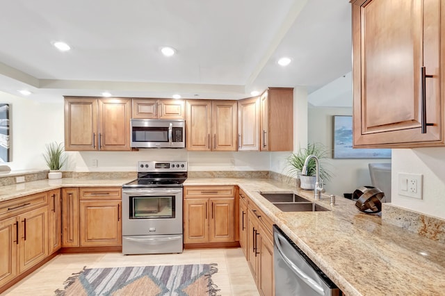 kitchen featuring light stone counters, sink, light tile patterned floors, and stainless steel appliances