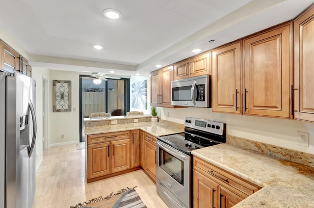 kitchen featuring kitchen peninsula, light stone counters, stainless steel appliances, ceiling fan, and light tile patterned floors