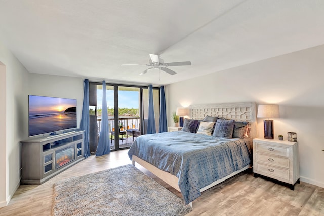 bedroom with ceiling fan, a wall of windows, wood-type flooring, and access to outside