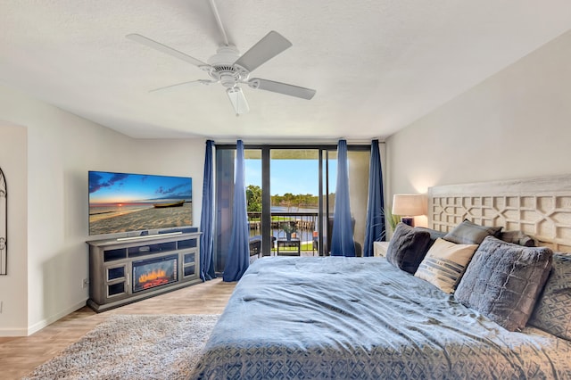 bedroom with a textured ceiling, light wood-type flooring, access to outside, and ceiling fan