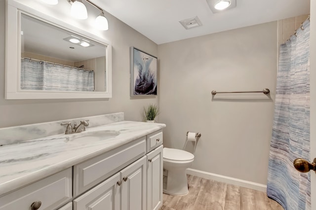 bathroom featuring toilet, vanity, and hardwood / wood-style flooring