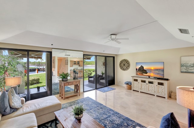 living room with ceiling fan and a tray ceiling