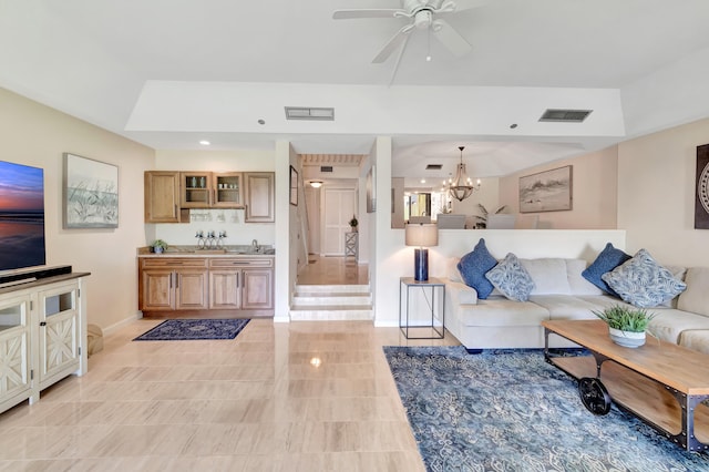 tiled living room featuring ceiling fan with notable chandelier and sink