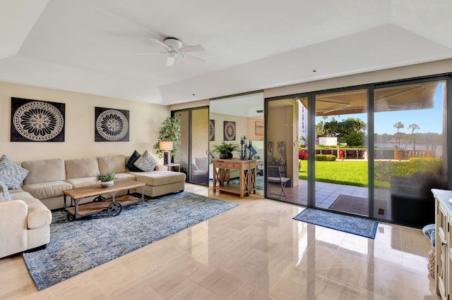 living room featuring a tray ceiling and ceiling fan