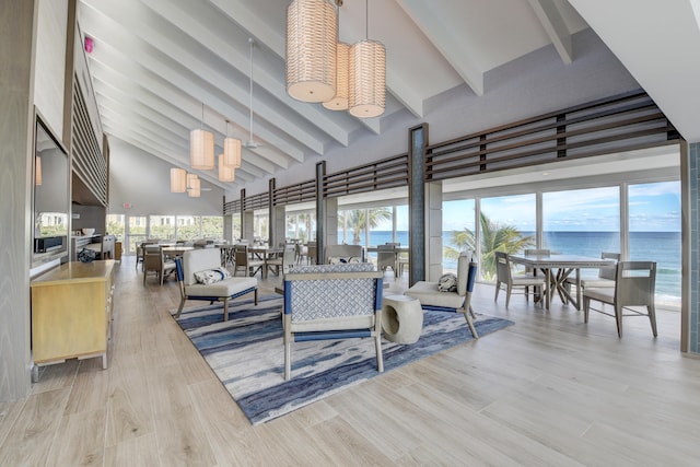 living room with beam ceiling, a water view, high vaulted ceiling, and a healthy amount of sunlight