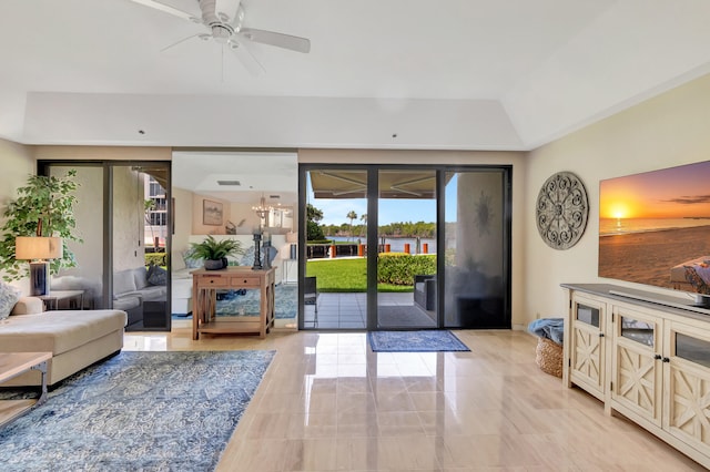 living room with a tray ceiling and ceiling fan with notable chandelier