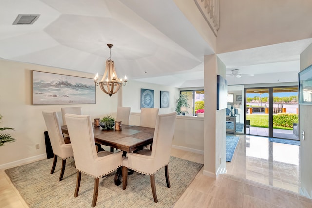 dining space featuring light tile patterned floors and ceiling fan with notable chandelier