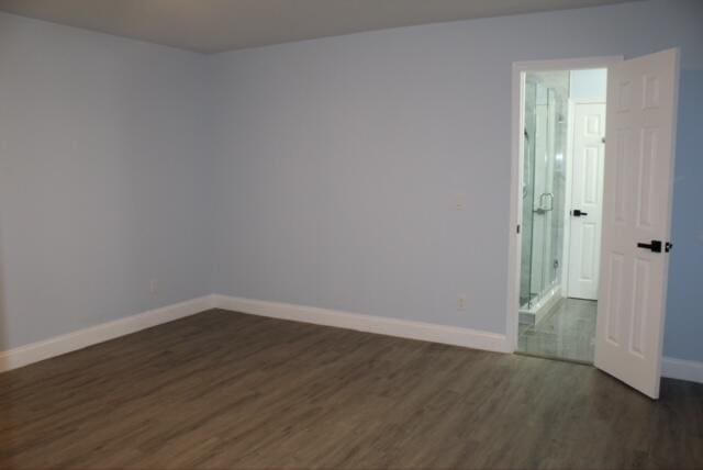 unfurnished room with dark wood-type flooring