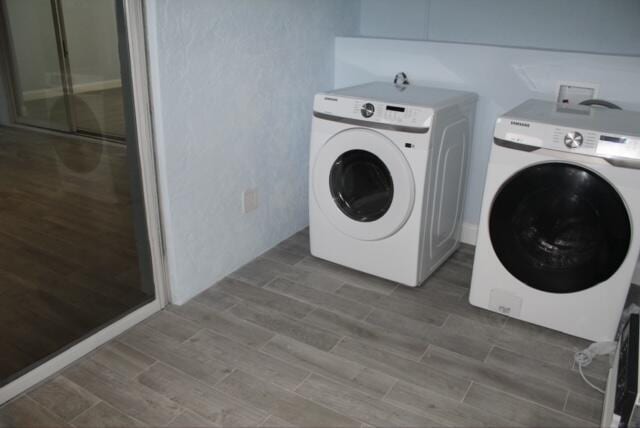 laundry room with washing machine and dryer and wood-type flooring