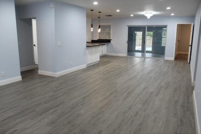 unfurnished living room with dark hardwood / wood-style flooring and french doors