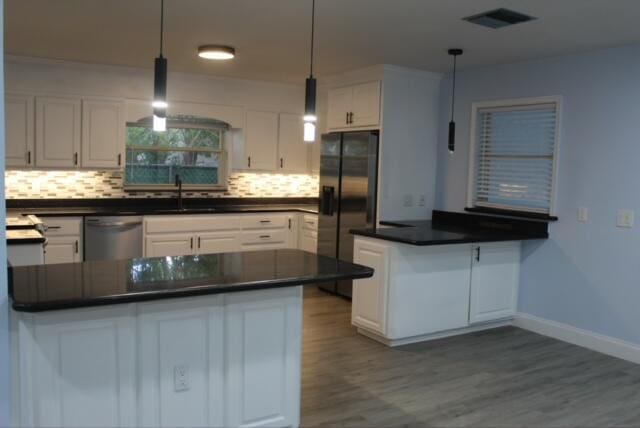 kitchen with dishwasher, black fridge with ice dispenser, decorative light fixtures, and white cabinetry