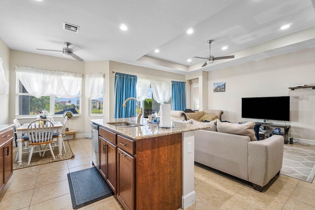 kitchen with a wealth of natural light, a kitchen island with sink, sink, and stainless steel dishwasher