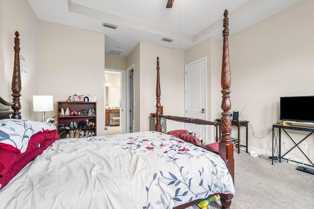 carpeted bedroom with ensuite bathroom and ceiling fan