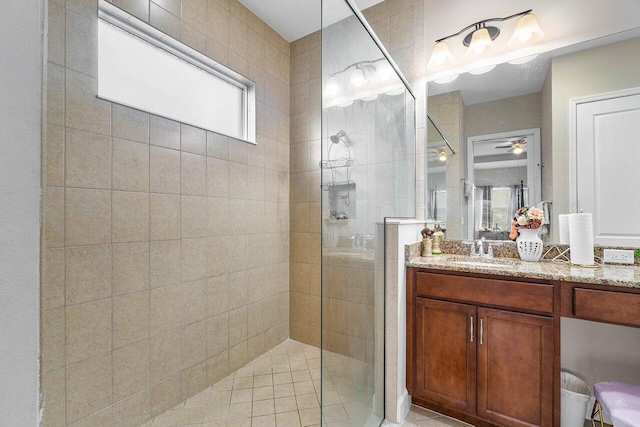 bathroom featuring a tile shower, vanity, and ceiling fan