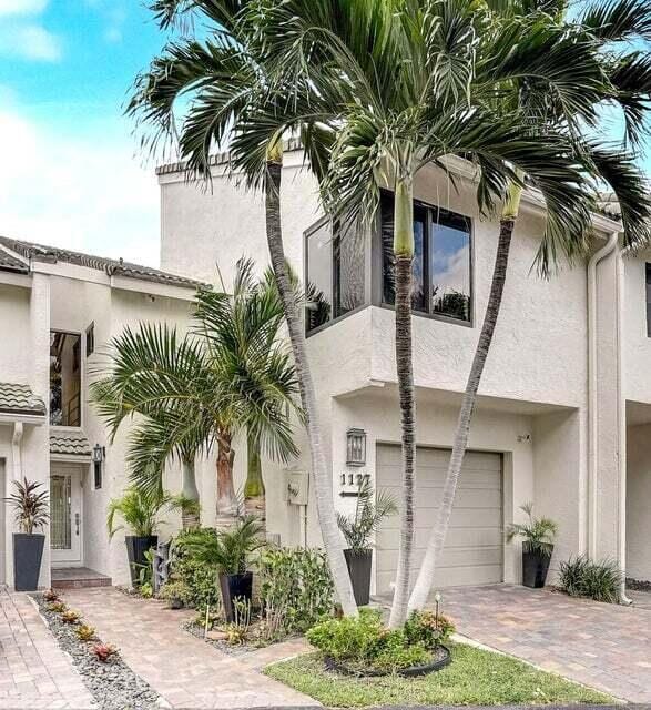 1127 Boca Cove Ln Unit 3, Highland Beach, FL 33487 - view of property exterior featuring a garage, stucco siding, and decorative driveway