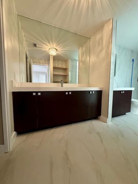 bathroom with marble finish floor, a marble finish shower, and vanity