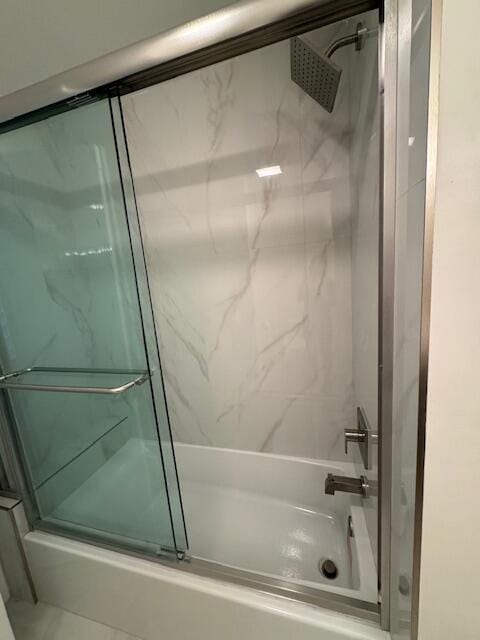 bathroom featuring shower / bath combination with glass door