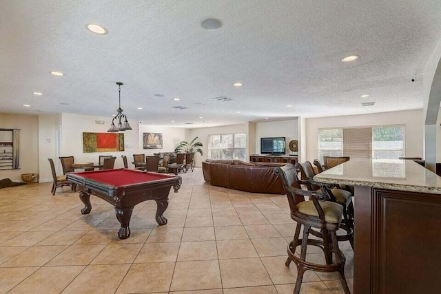 rec room with a textured ceiling, billiards, and light tile patterned floors