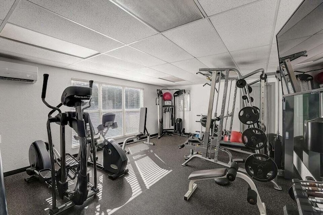 1127 Boca Cove Ln Unit 3, Highland Beach, FL 33487 - exercise room with an AC wall unit, a drop ceiling, and baseboards