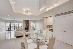 dining room featuring a fireplace, a raised ceiling, and a wealth of natural light