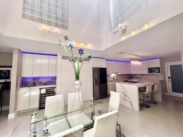 1127 Boca Cove Ln Unit 3, Highland Beach, FL 33487 - dining room featuring beverage cooler, a high ceiling, and light tile patterned floors