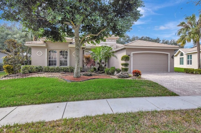 mediterranean / spanish home featuring a garage and a front lawn