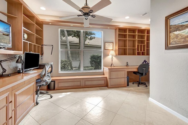 office featuring built in desk, ceiling fan, and light tile patterned flooring