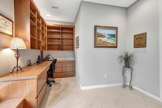 office area with light tile patterned flooring and built in desk